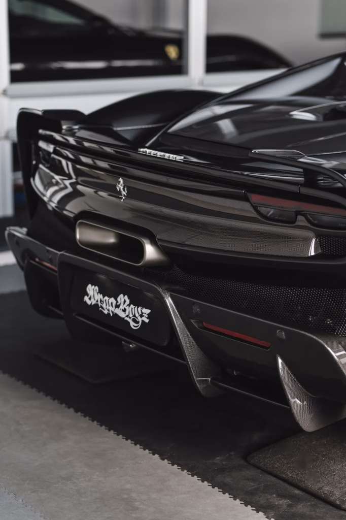 Dettaglio posteriore di un’auto sportiva nera nel laboratorio Wrap Boyz